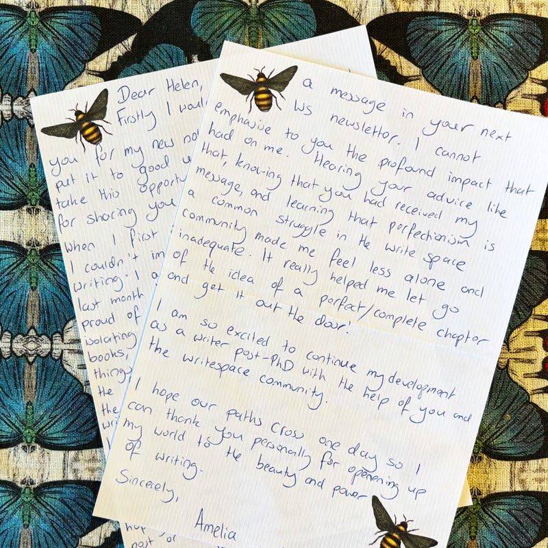 A handwritten letter on a colorful tablecloth with a moth pattern