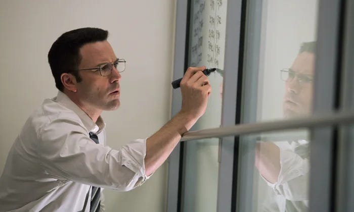 Person writing financial calculations on a glass wall, representing the complexity of modeling SAFE ownership and dilution.