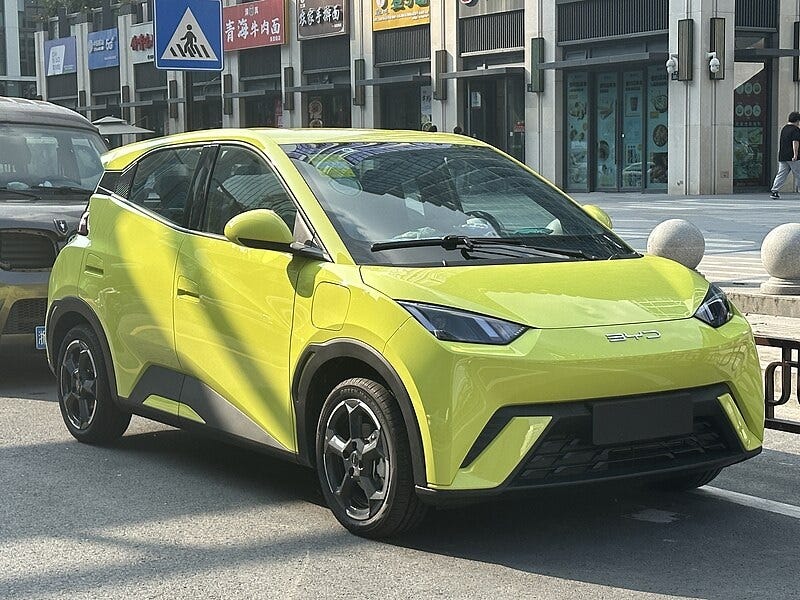 A small yellow-green 4-door compact electric car, the BYD Seagull A small yellow-green 4-door compact electric car, the BYD Seagull