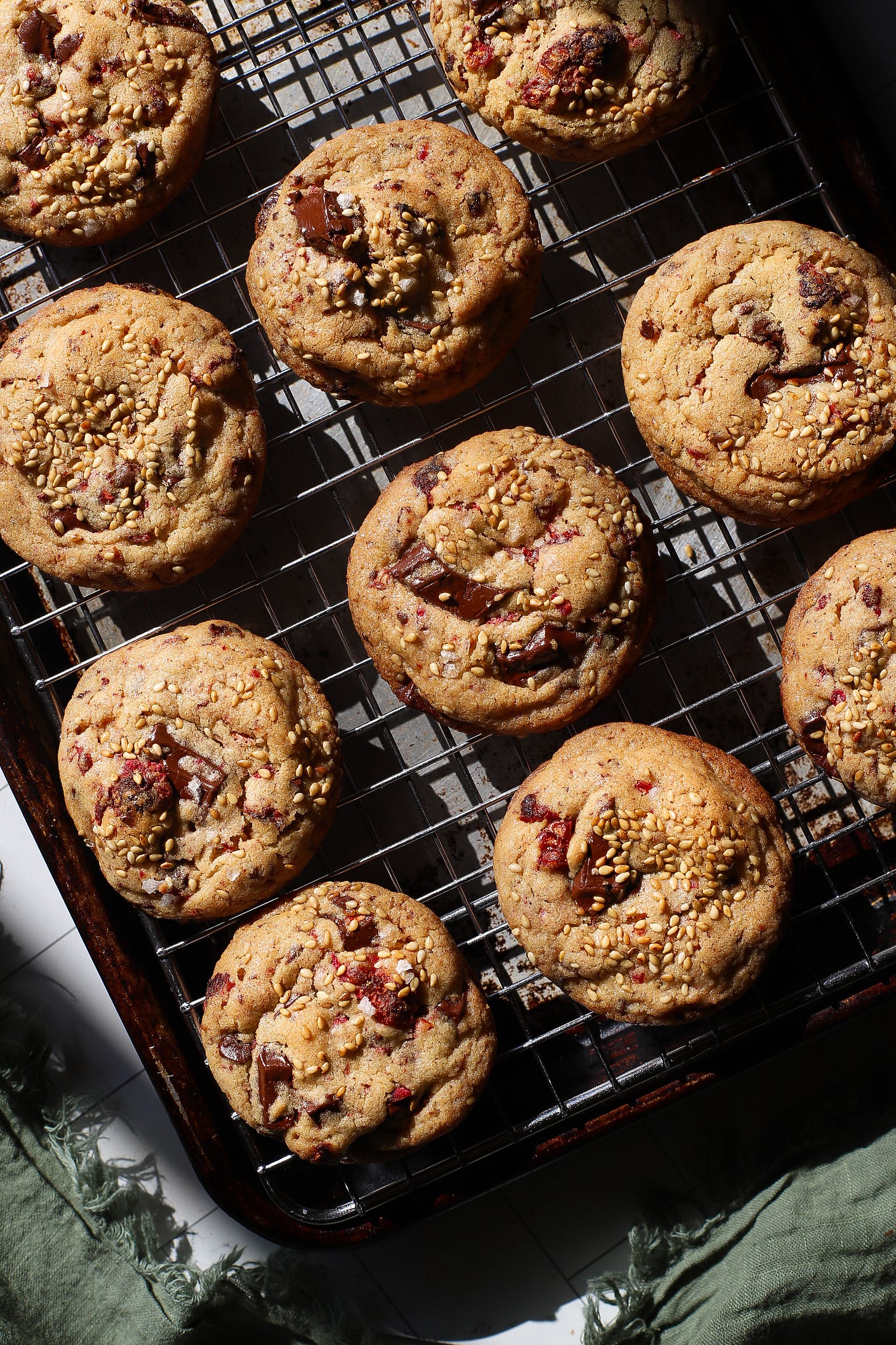 Tahini raspberry chocolate chip cookies sitting on a baking rack
