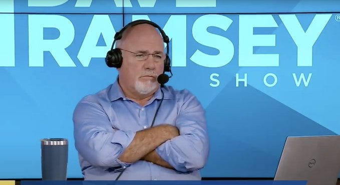 Man with glasses and gray hair wearing a headset and light blue button-up shirt sits at a desk with arms crossed. He faces forward with a neutral expression. A silver tumbler and silver laptop are on the desk in front of him. Blue backdrop features white text reading Dave Ramsey Show. Man with glasses and gray hair wearing a headset and light blue button-up shirt sits at a desk with arms crossed. He faces forward with a neutral expression. A silver tumbler and silver laptop are on the desk in front of him. Blue backdrop features white text reading Dave Ramsey Show.
