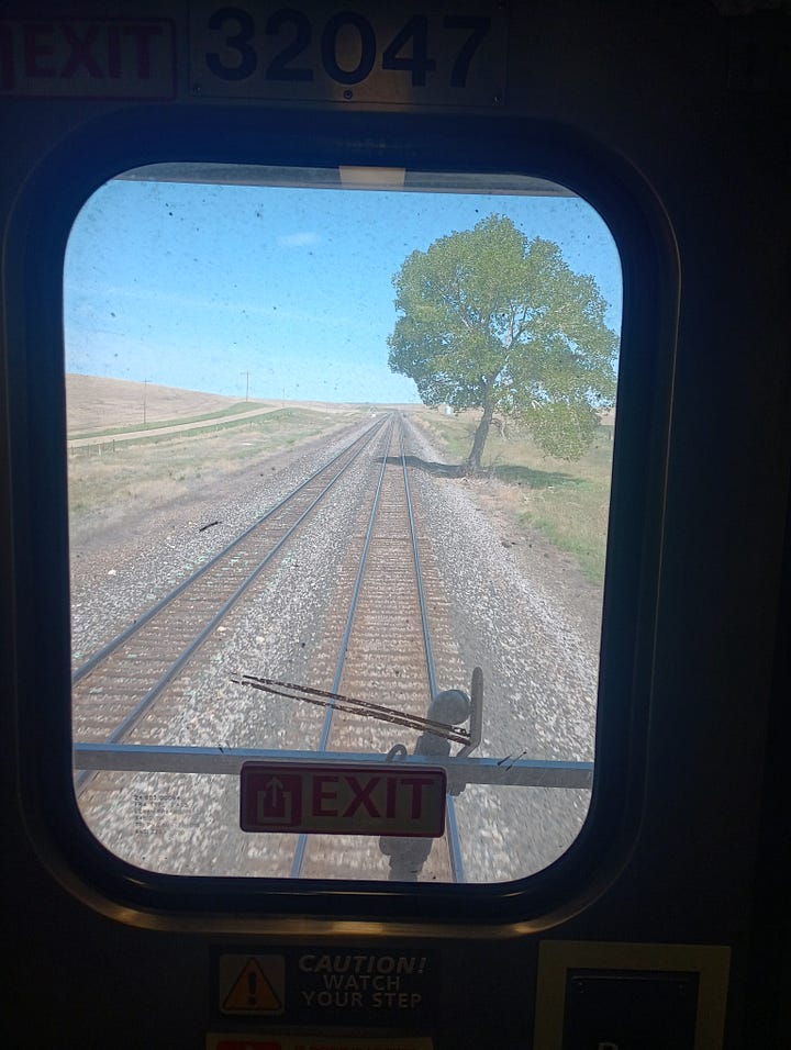 train room with a bath, and roomette, looking at the track behind the last car, looking down the very narrow hallway