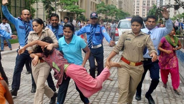 Police in action against local villagers who gathered at a housing society to protest after a domestic help was allegedly beaten by her employers on suspicion of theft, in Noida on Wednesday (PTI)
