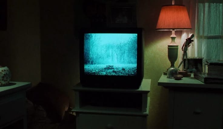This may contain: a television sitting on top of a table in a living room next to a lamp