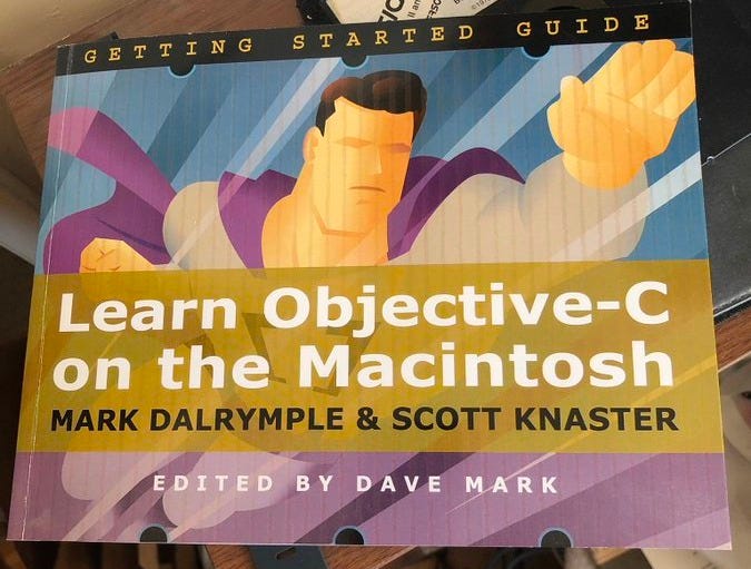 Cover of "Learn Objective-C on the Macintosh". Cover image includes a character who looks kind of like Superman, but with a blurry face and a purple costume. So, it's not Superman. Definitely not.