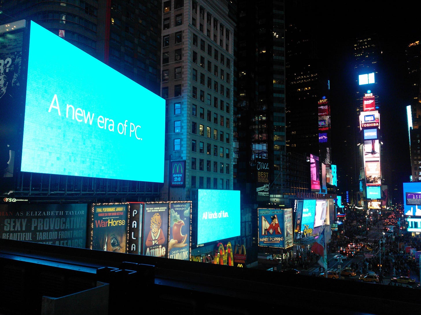 A nighttime view of Times Square New York during the Surface Block Party, October 25, 2012. There is a huge screen that says "A new era of PC" in the style of a metro-style rectangle. A nighttime view of Times Square New York during the Surface Block Party, October 25, 2012. There is a huge screen that says "A new era of PC" in the style of a metro-style rectangle.