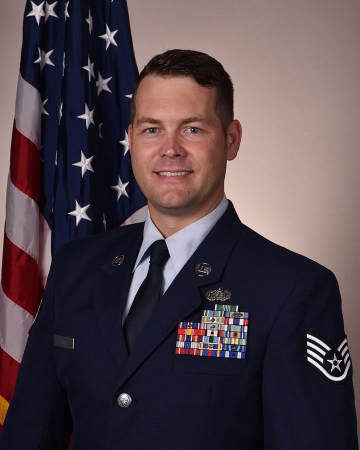 A close-up portrait of Edward Hood smiling wearing his white beret with the 1D7X1W badge and a blue checkered button-up shirt, set against a plain gray background. The other picture is his official military portrait.