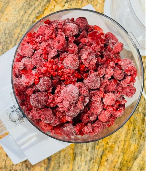 Homemade raspberry sorbet, deep pink and glossy, made with fresh raspberries, spun in a food processor, with sugar, lemon juice, sea salt, vanilla extract, and churned in an ice cream maker