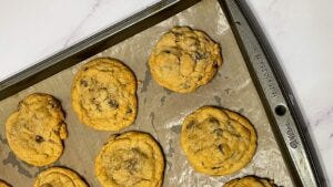 Baked chocolate chip cookies on a pan.