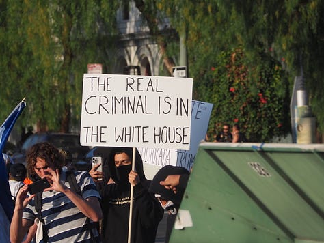Protesters begin vandalizing police vehicles that are parked on the 101 freeway.