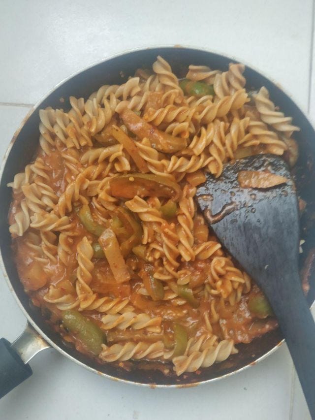 A bowl of red pasta with veggies. A bowl of red pasta with veggies.
