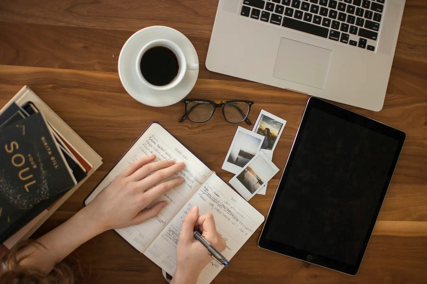 a writer at their laptop editing a story in their journal