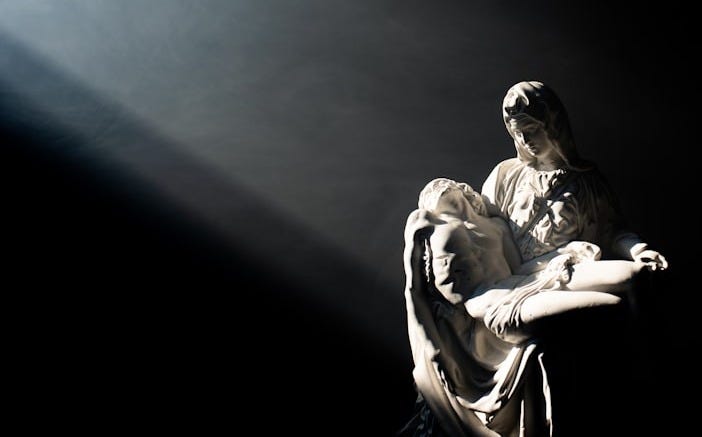 man in white and black jacket and pants sitting on black surface