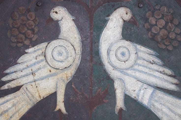 This may contain: two white birds painted on the side of a building