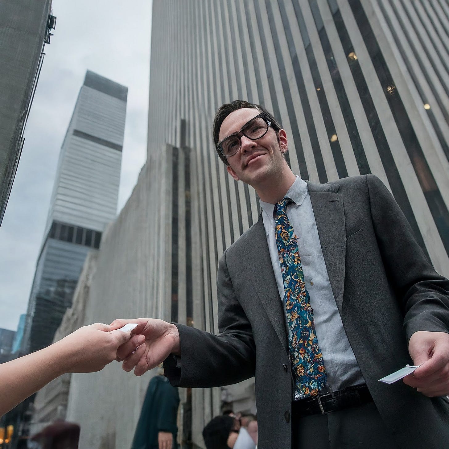 a nerdy white collar professional standing outside of an office skyscraper in downtown manhattan trying to meet people by handing out his business card and shaking their hands a nerdy white collar professional standing outside of an office skyscraper in downtown manhattan trying to meet people by handing out his business card and shaking their hands