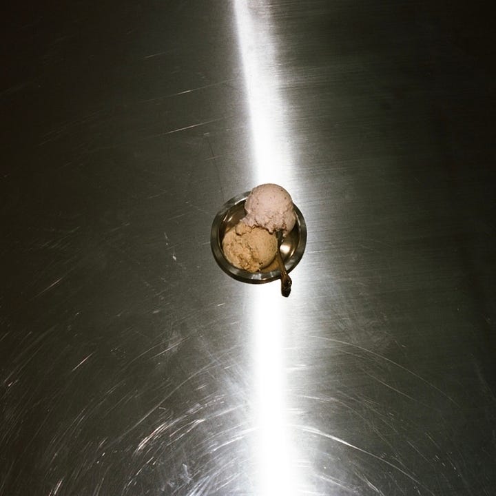 Nicky Fisher scoops ice cream into a steel cup.