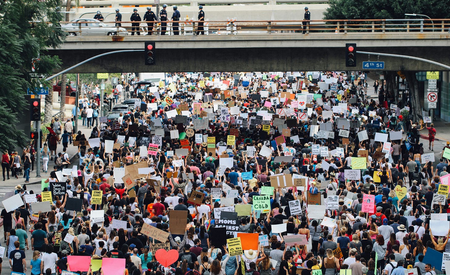 A large crowd of people, protesting, and holding up signs