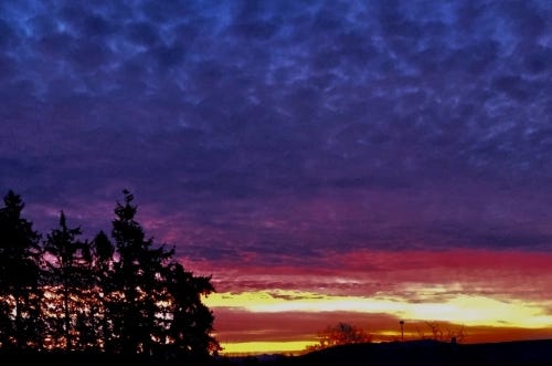 A vivid multi-layered sunset creates patterns of light like those off of abalone shells.