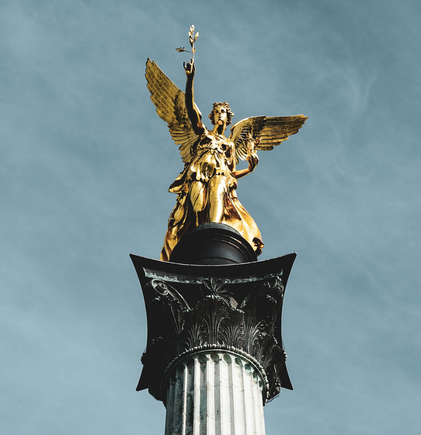 The golden statue at the top of a victory column.