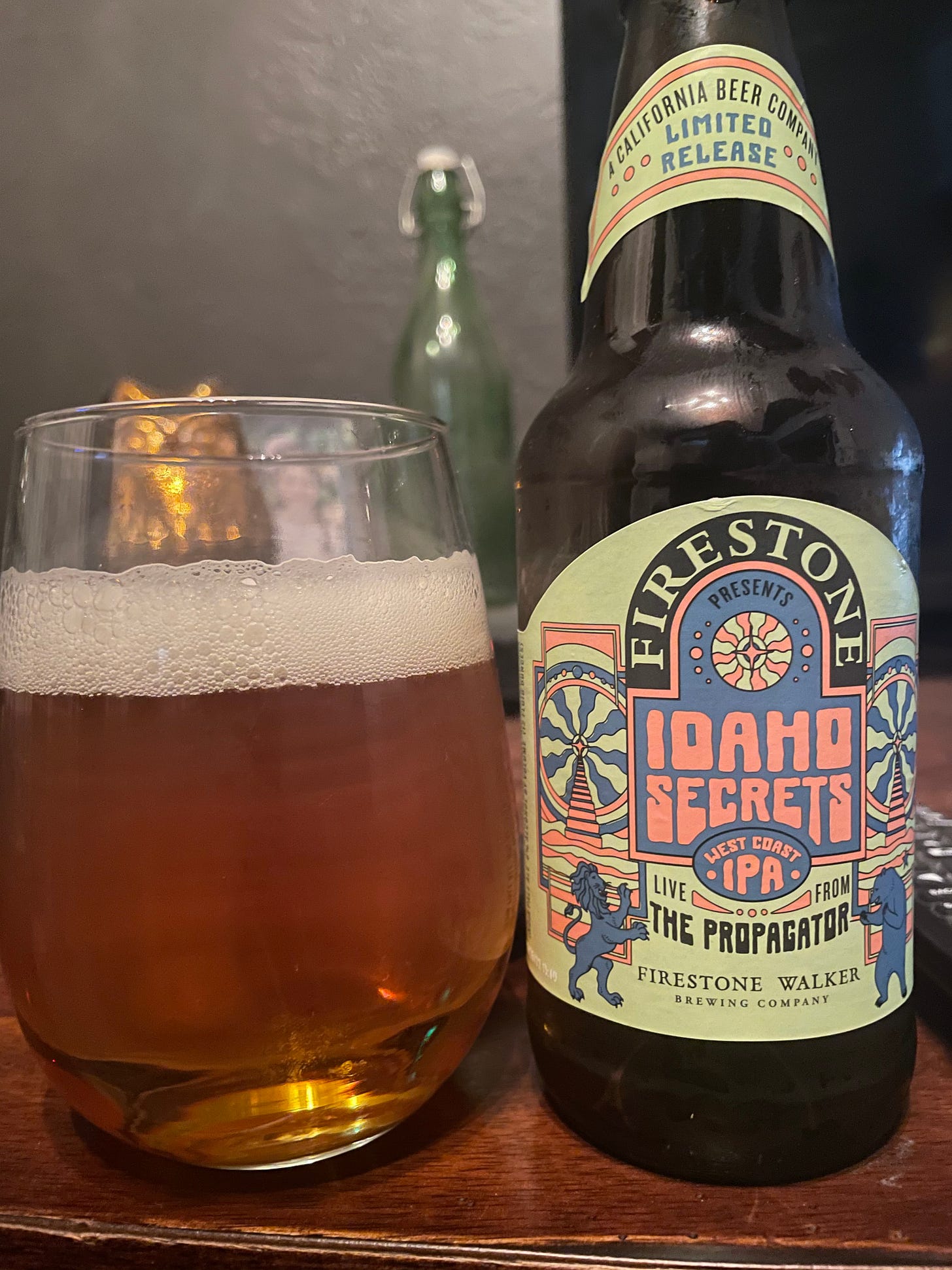 A glass of beer with an Firestone Walker “Idaho Secrets IPA” bottle next to it