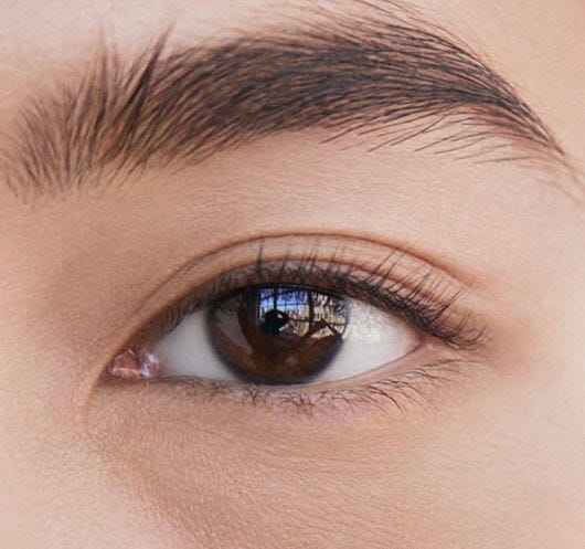 Two images of a woman's eye, one showing eyelashes limp and the other showing them upright and curled