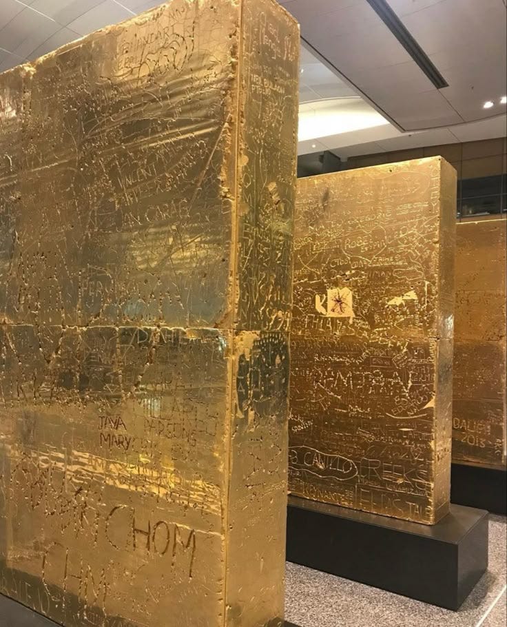 This may contain: three large golden blocks with writing on them