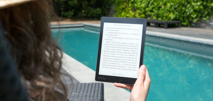 A woman reads from her digital device.