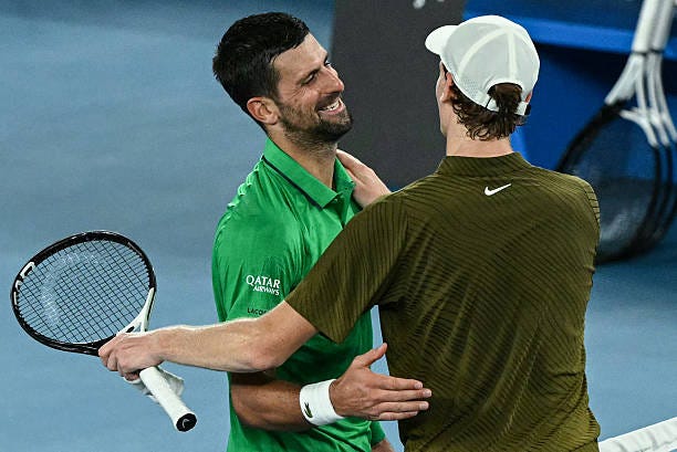 Serbia's Novak Djokovic greets Italy's Jannik Sinner after winning their men's singles semi-final match on day thirteen of the Australian Open tennis...