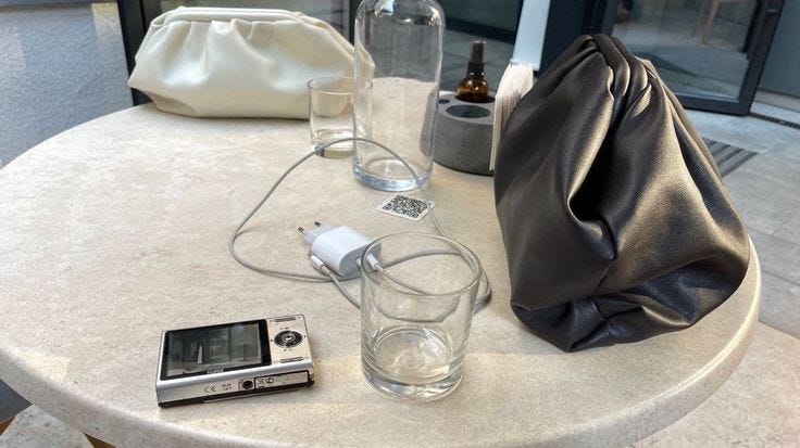 This may contain: a table with a cell phone, camera and other items sitting on top of it