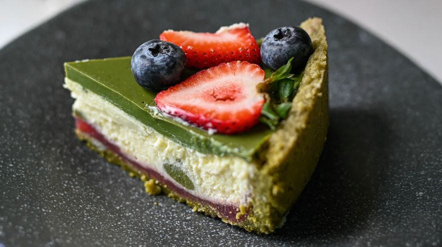 Slice of matcha cheesecake topped with green tea powder Slice of matcha cheesecake topped with green tea powder