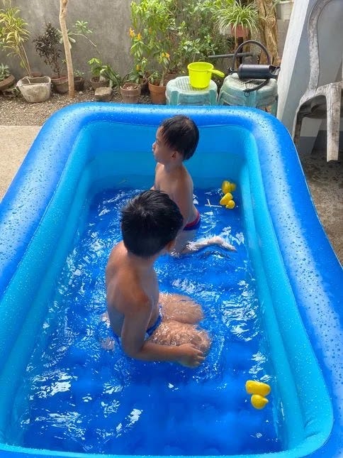 Two children swimming in an inflatable pool Two children swimming in an inflatable pool