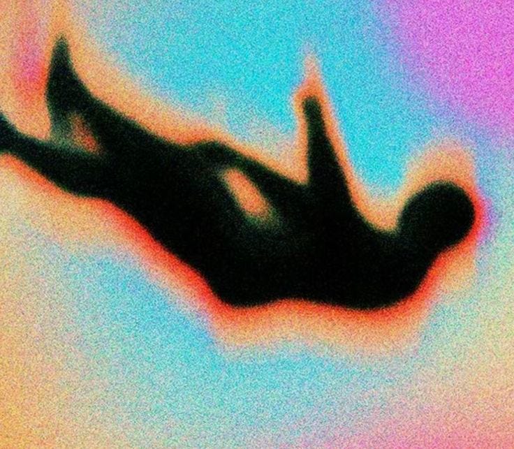 This may contain: a blurry image of a person in the air with their feet up and arms out