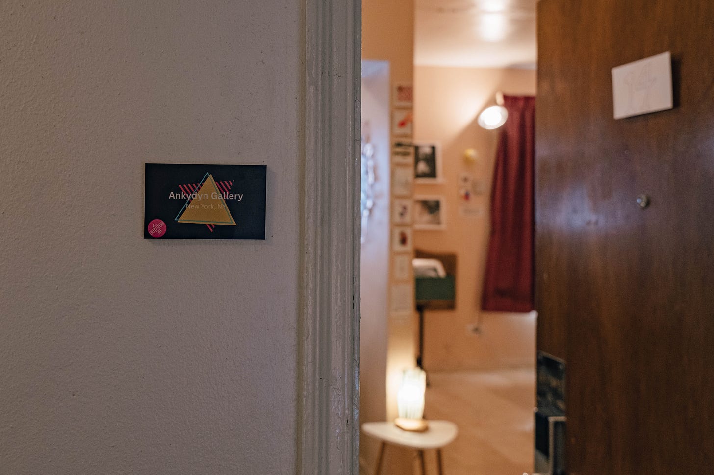 Gallery sign on the wall with an open door into the gallery space