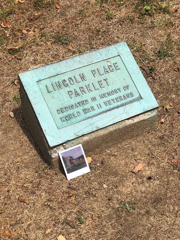 Marker for the WWII memorial in the "Lincoln Place Parklet" likely pre-playground days.