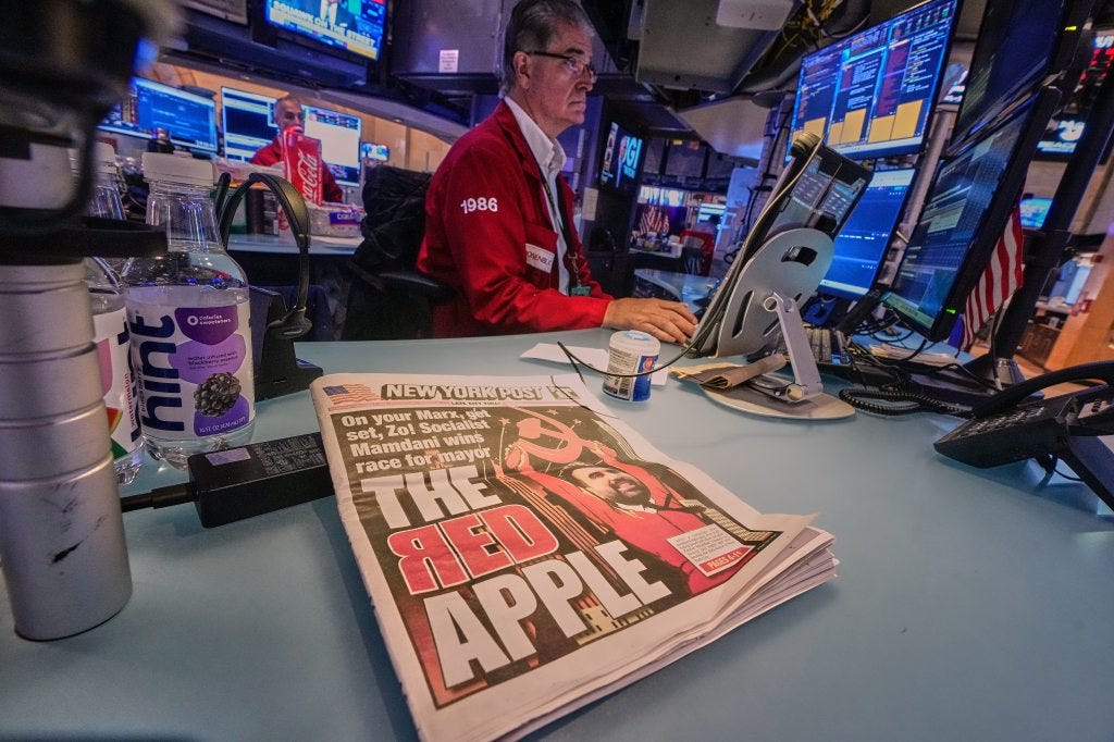 A copy of the New York Post headlines Zohran Mamdani's New York mayoral victory, at the post of trader Daniel Kryger, center, on the floor of the New York Stock Exchange, Wednesday, Nov. 5, 2025.