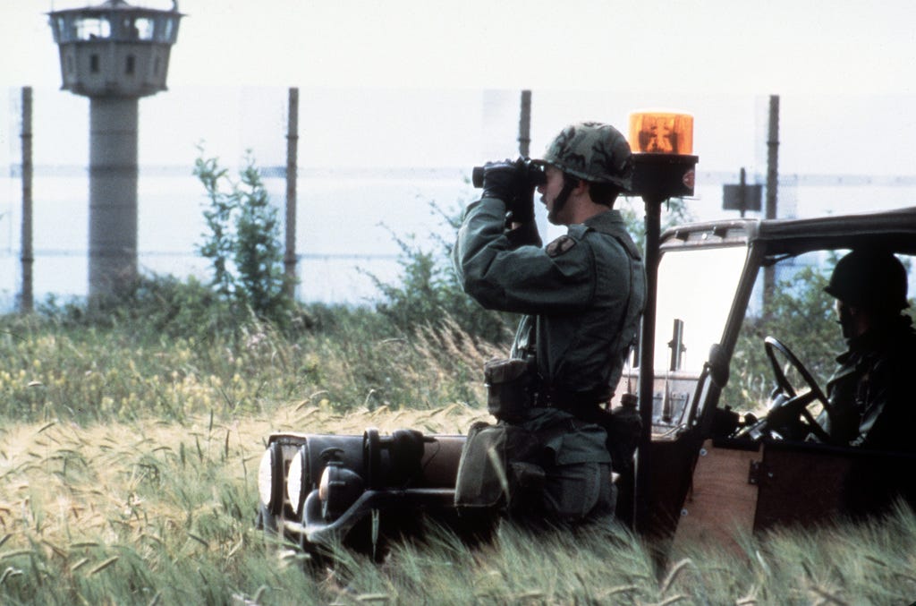 Members of the U.S. Army's Berlin Brigade observe a segment of the Berlin  Wall from the West German side. Members of the wall patrol are chosen from  brigade units on a rotating