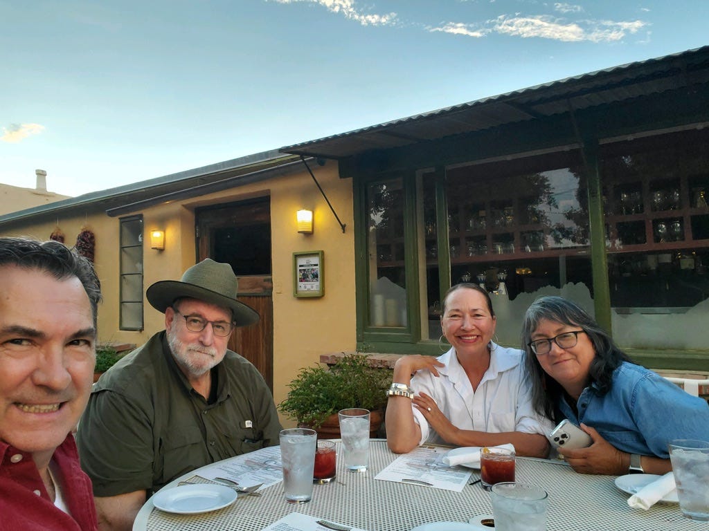 A group of people sitting at a table outside

Description automatically generated