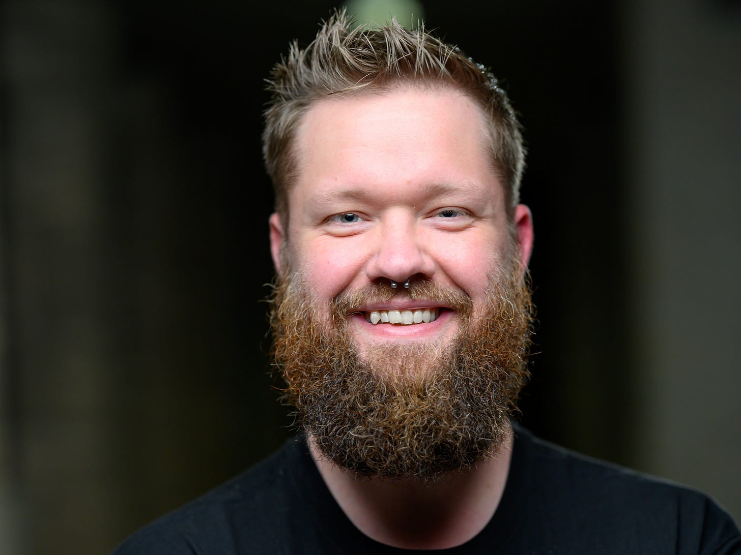 Tim Tenor wearing a black t-shirt and smiling.