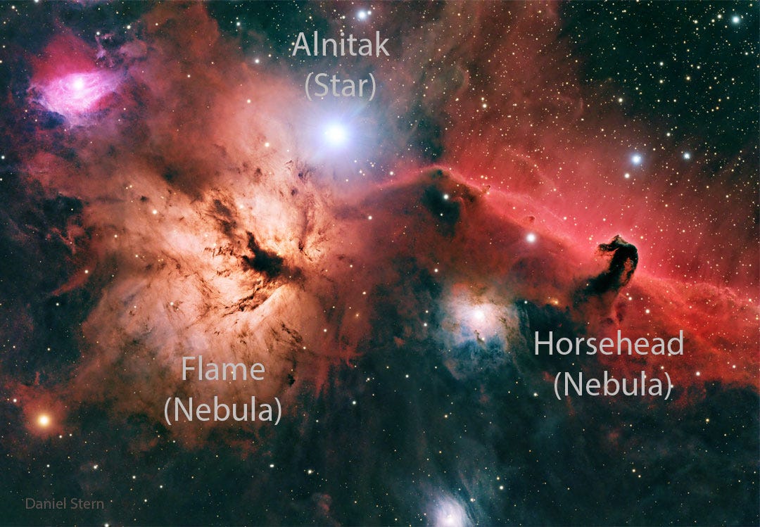 A starfield is shown with bright and dark nebulae of 
different shapes and colors.
Please see the explanation for more detailed information.