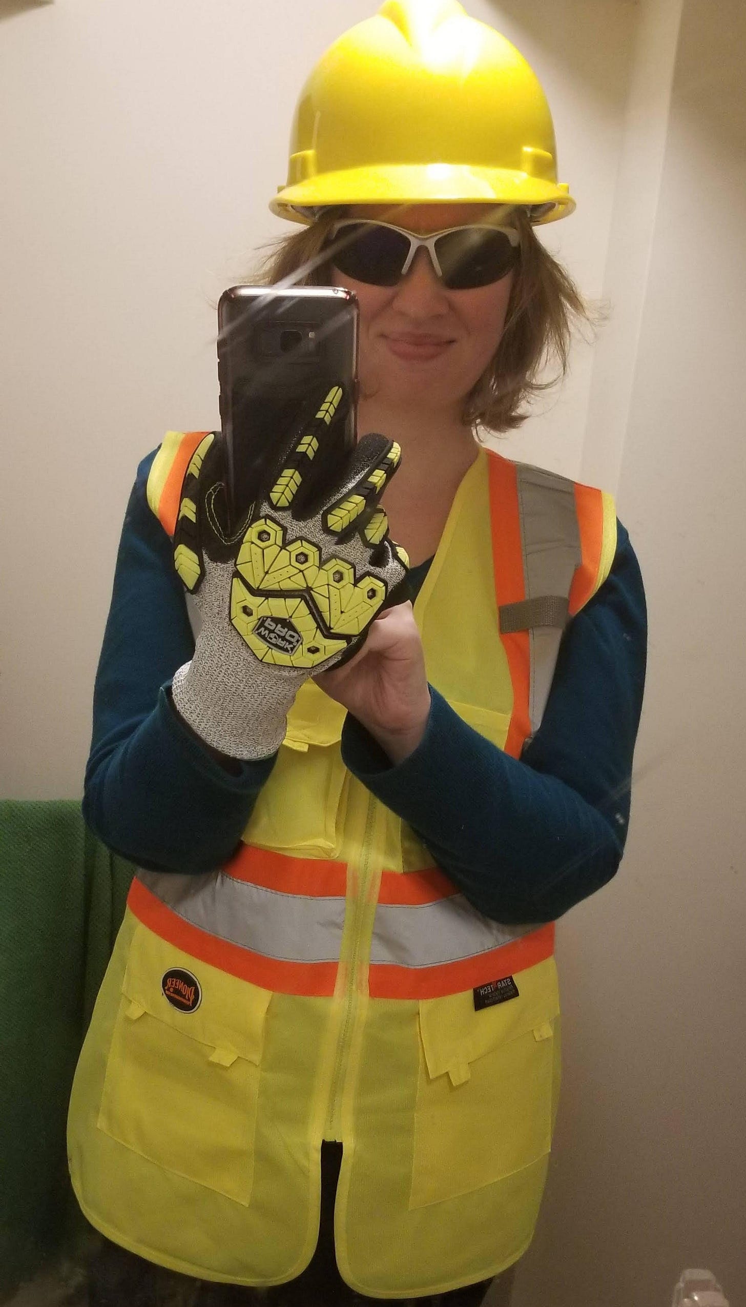 A selfie of me wearing a yellow hard hat, safety sunglasses, safety gloves, and a yellow and orange safety vest. A selfie of me wearing a yellow hard hat, safety sunglasses, safety gloves, and a yellow and orange safety vest.