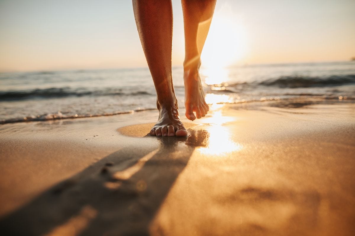 Bare feet walking in sand