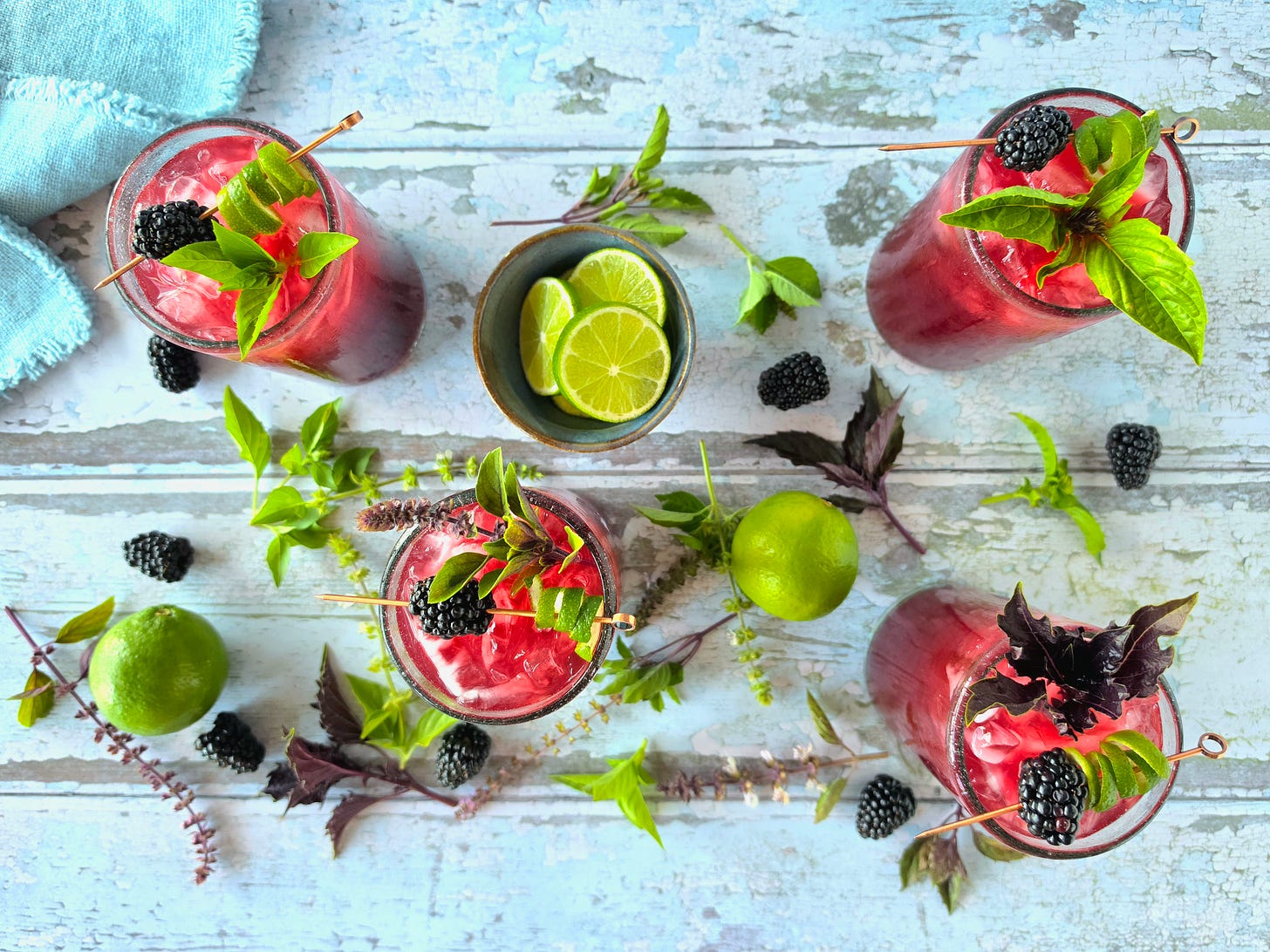 an overhead view of 4 cocktails with garnishes and a napkin