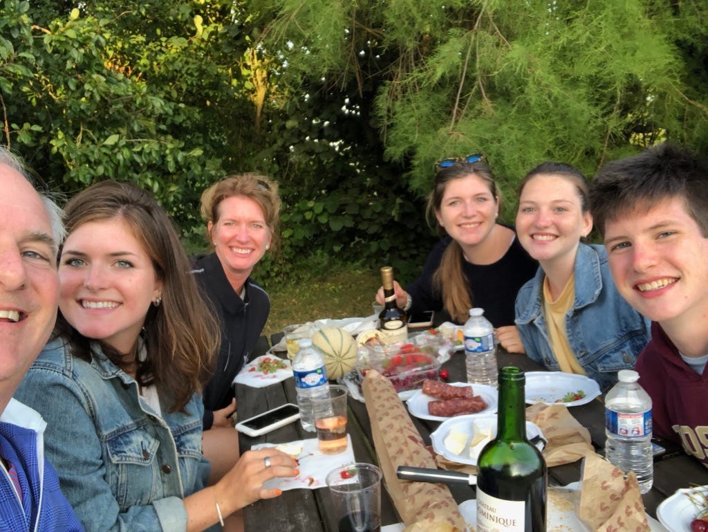 Jill and her husband eating dinner outside with their four adult kids Jill and her husband eating dinner outside with their four adult kids