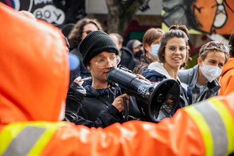 first image: one person is calling out on a megaphone and another just beside is yelling along. i forget exactly what but something to the effect of "fuck the police." second image: person with the megaphone is making snarky comments at a guy with a camera who's been called out by others as being a fascist. i don't know who the guy is who was being called a fascist or his name. last image: VANDU organizer Vince Tao on the microphone