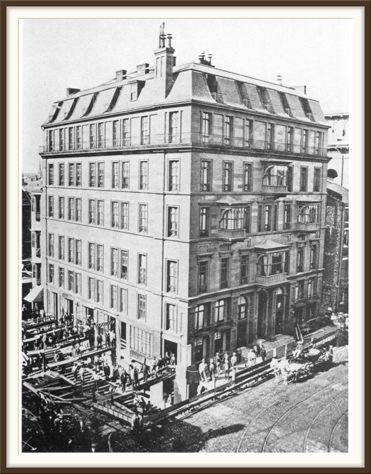 A house up on timbers in the middle of Central Street, a horse walking a circle at a capstan