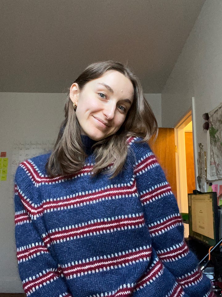 Paola wears a fluffy dark blue sweater with red-and-white stripes—her first hand-knit colorwork sweater.