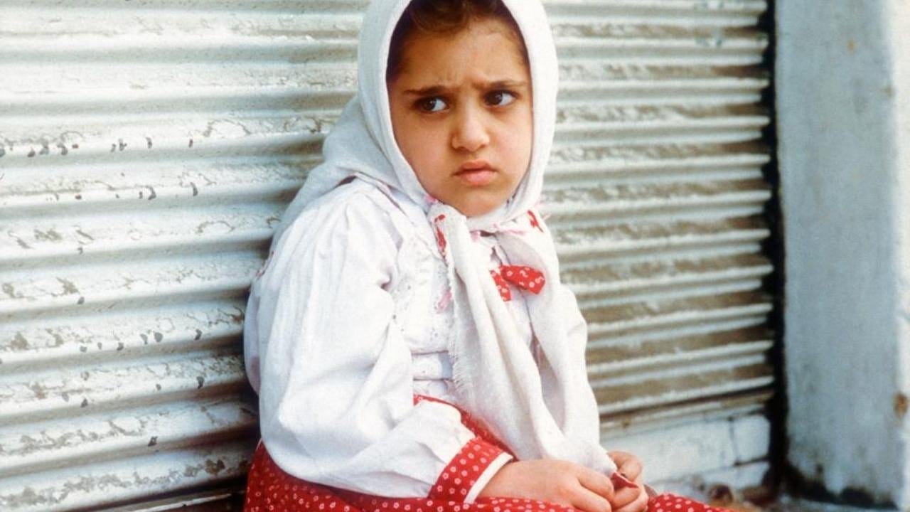 The White Balloon | Still features Aida Mohammadkhani as Razieh sitting against a wall.