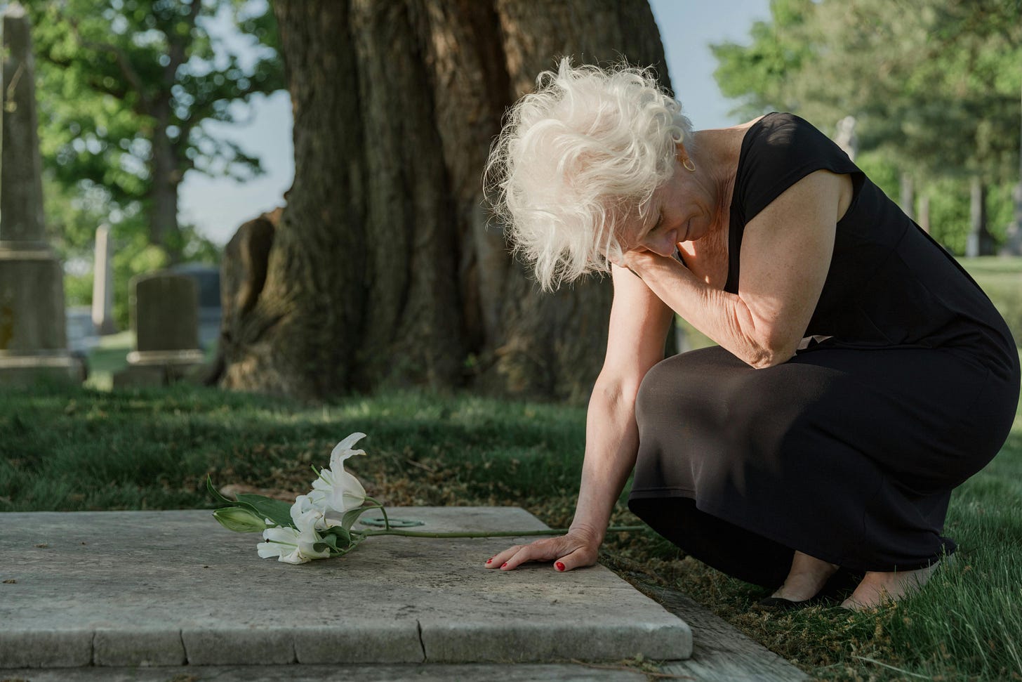 Photo of an Elderly Woman Grieving at a Grave · Free Stock Photo
