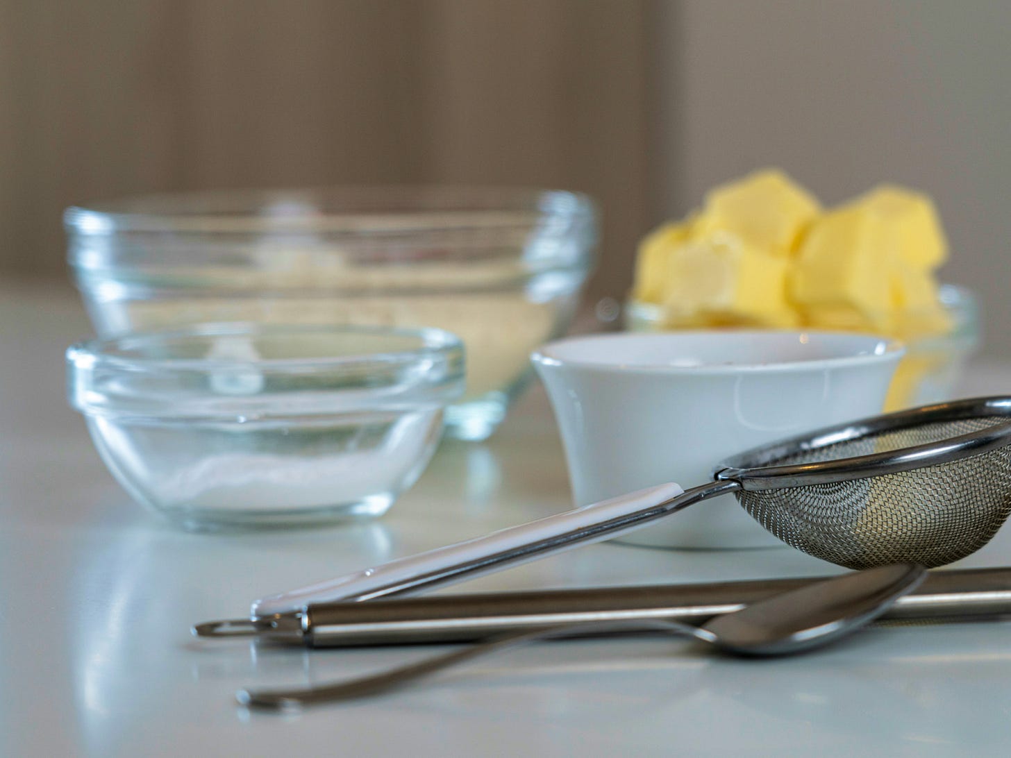baking tools including sieve, spoon, and measuring bowls