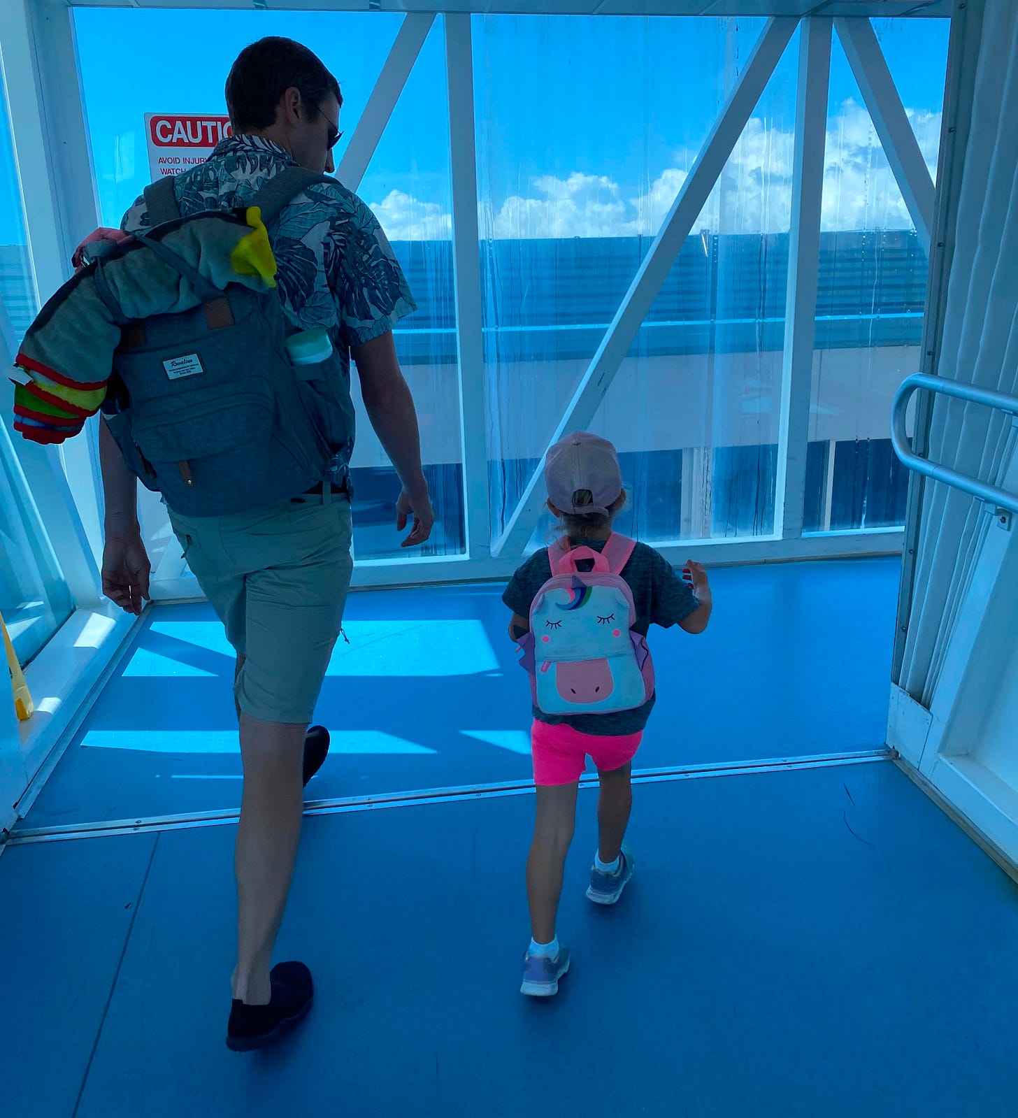 a father and his daughter walking up the embarkation bridge to board a cruise ship together a father and his daughter walking up the embarkation bridge to board a cruise ship together